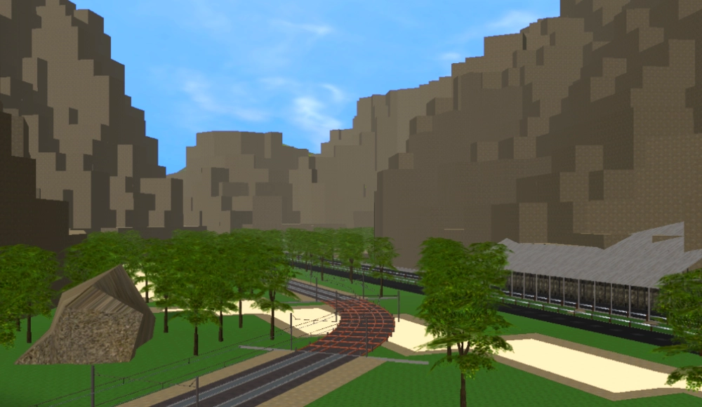 An electric train track runs into a box canyon next to a road